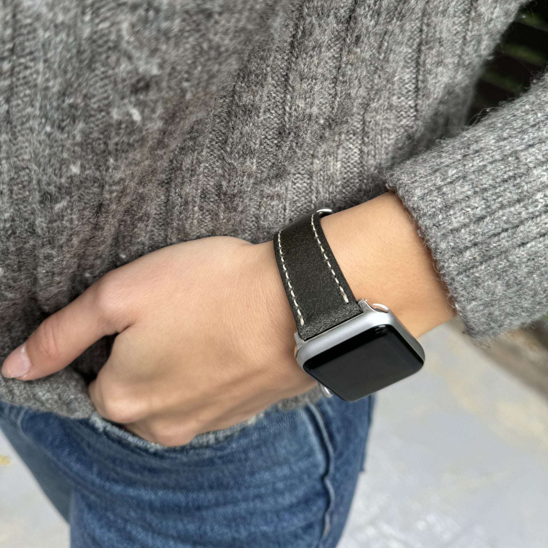 Das Apple Watch Lederarmband Vintage in braun, gut sichtbar neben einer offenen Uhr auf dem Tisch. Es passt perfekt zu 38mm und 42mm Modellen.