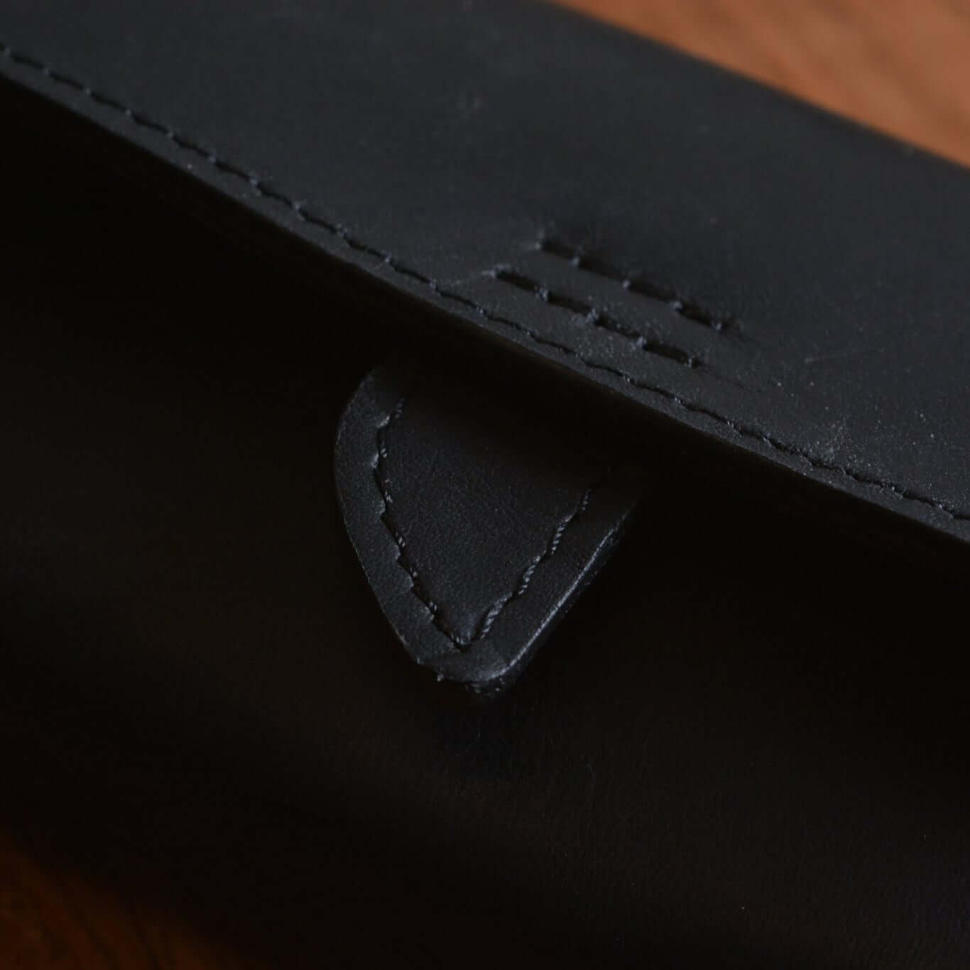 Close-up of FLUCO x The Urban Gentry Pocket Watch Case, showcasing detailed stitching and black leather finish.