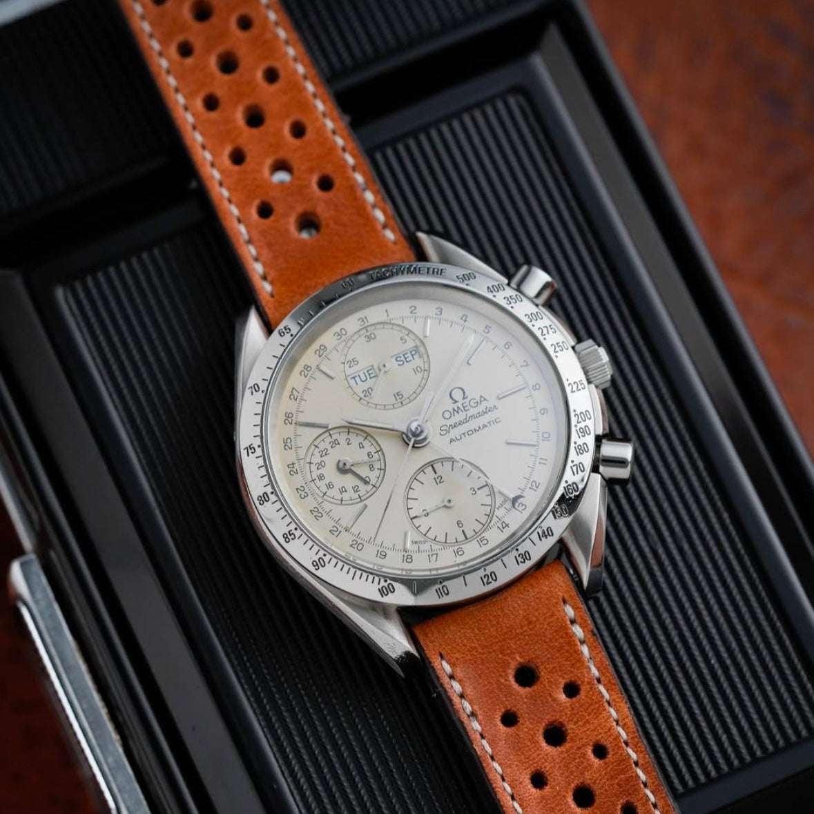 Hellbraunes Horween Dublin Leder Racing Uhrenarmband an Omega Speedmaster White Dial – Detailaufnahme der Omega Speedmaster White Dial Uhr mit strapazierfähigem hellbraunem Horween Dublin Lederarmband, das der Uhr einen eleganten und sportlichen Look verleiht