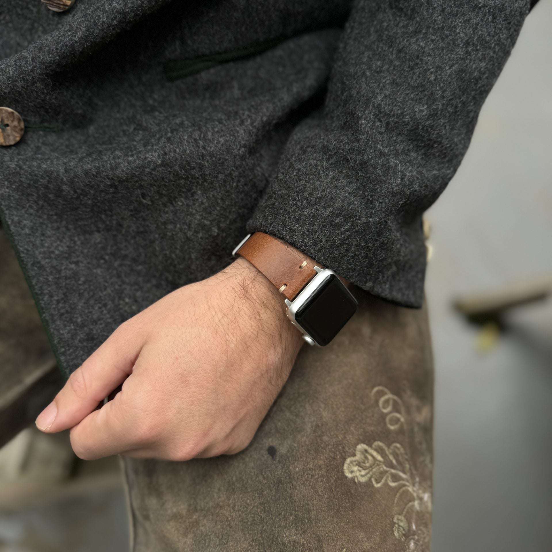 Tragebild des braunen Apple Watch Armband Leder Herren, stilvoll am Handgelenk eines Trägers abgebildet.