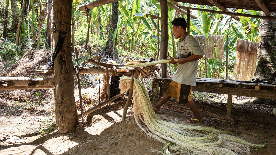 Mann in den Philippinen verarbeitet Natur Bananenfasern mit traditioneller Technik in einer ländlichen Hütte, um nachhaltige Materialien in tropischer Umgebung zu gewinnen.