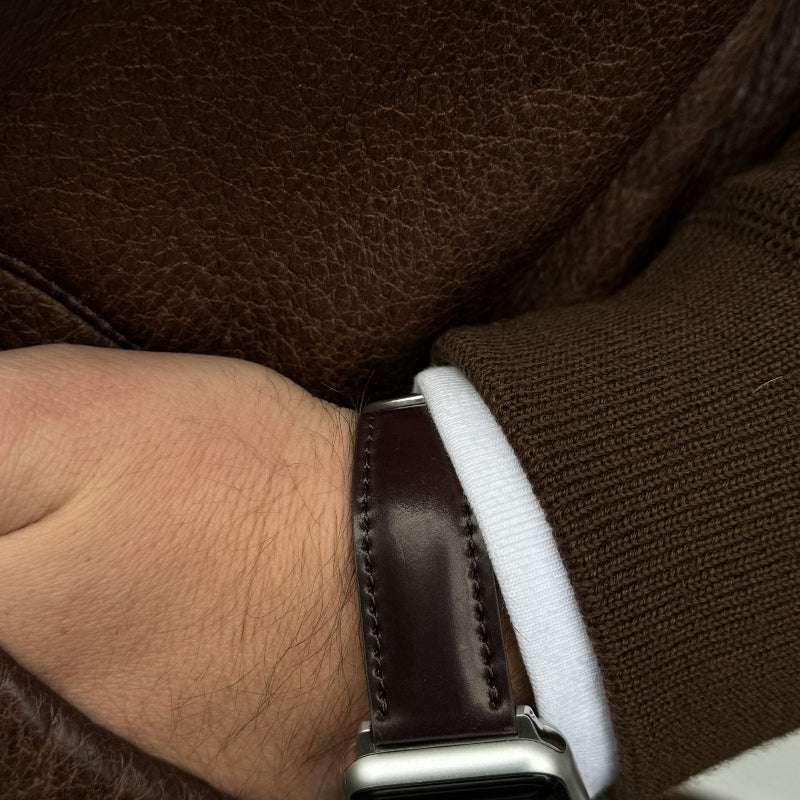 Ansicht des handgelenk mit einem apple watch armband luxus aus Horween Cordovan und einer modischen Jacke. Apple Watch Band, aus horween shell cordovan.