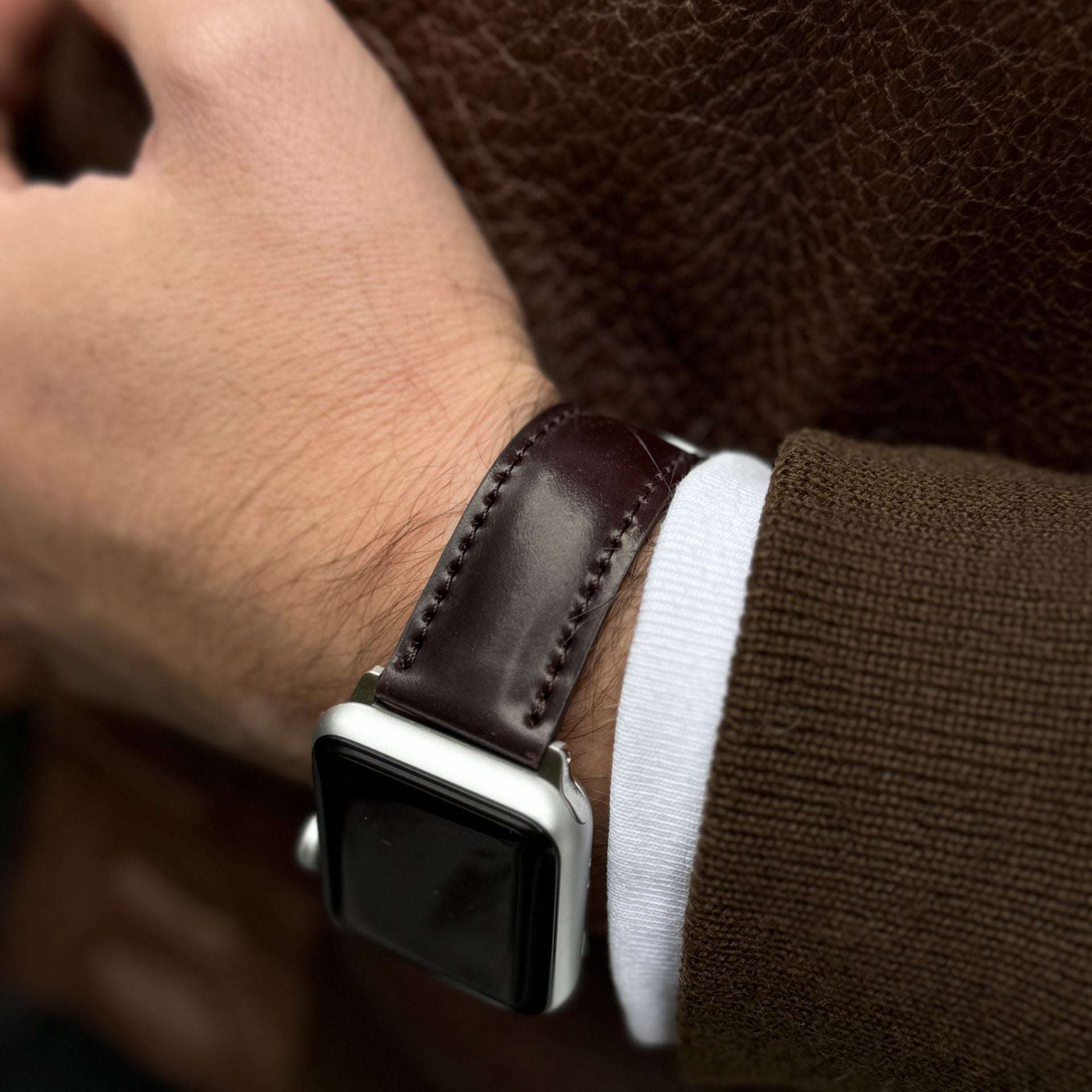 Das apple watch armband luxus aus Horween Cordovan an einem Handgelenk mit eleganter Jacke. Apple Watch Band, aus horween shell cordovan.