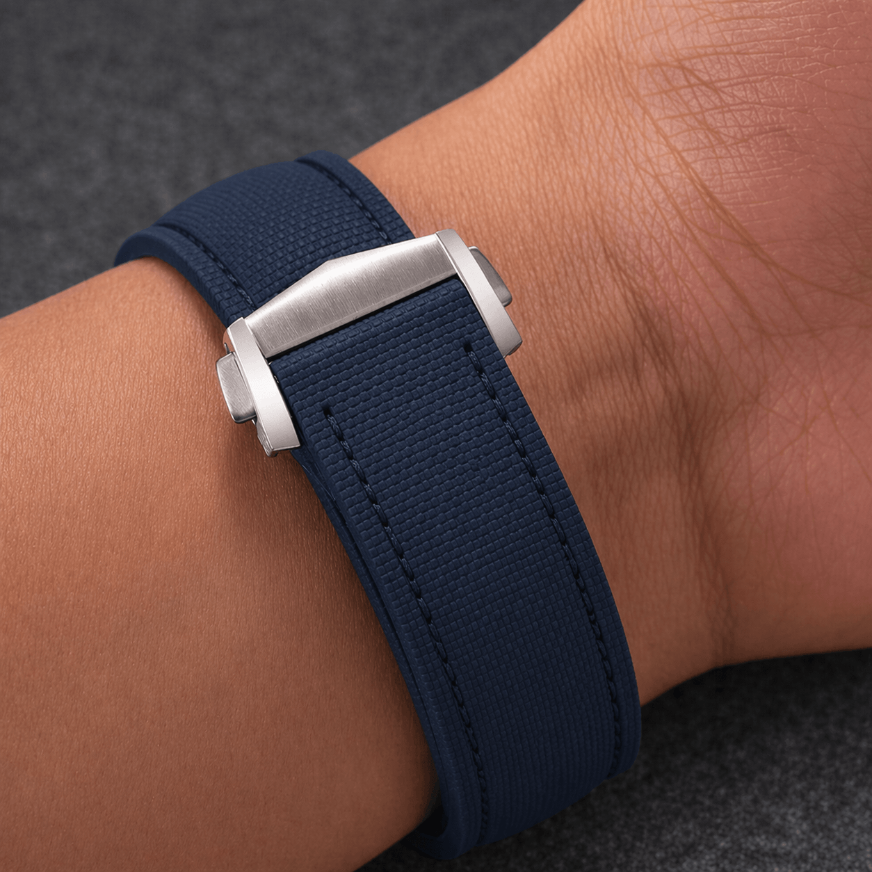 Monaco – Faltschließen Uhrenarmband aus FKM Kautschuk, dunkelblaues Armband mit Faltschließe auf Handgelenk.