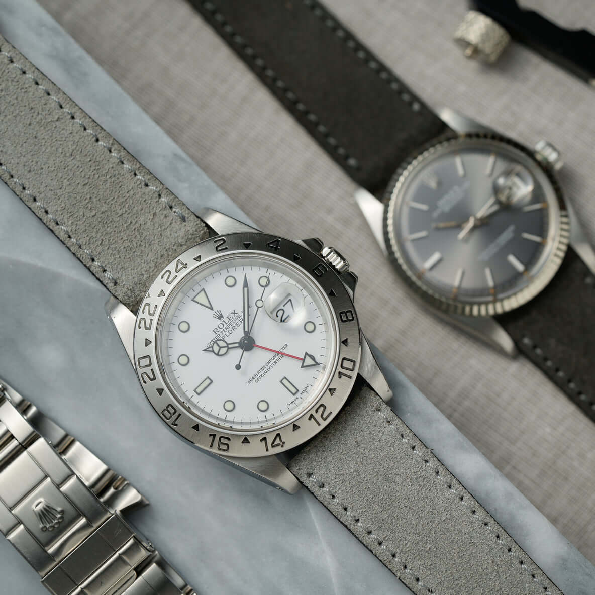 Nizza – Uhrenarmband aus feinem Wildleder präsentiert an einer modischen Uhr mit grauem Zifferblatt auf Marmortisch.