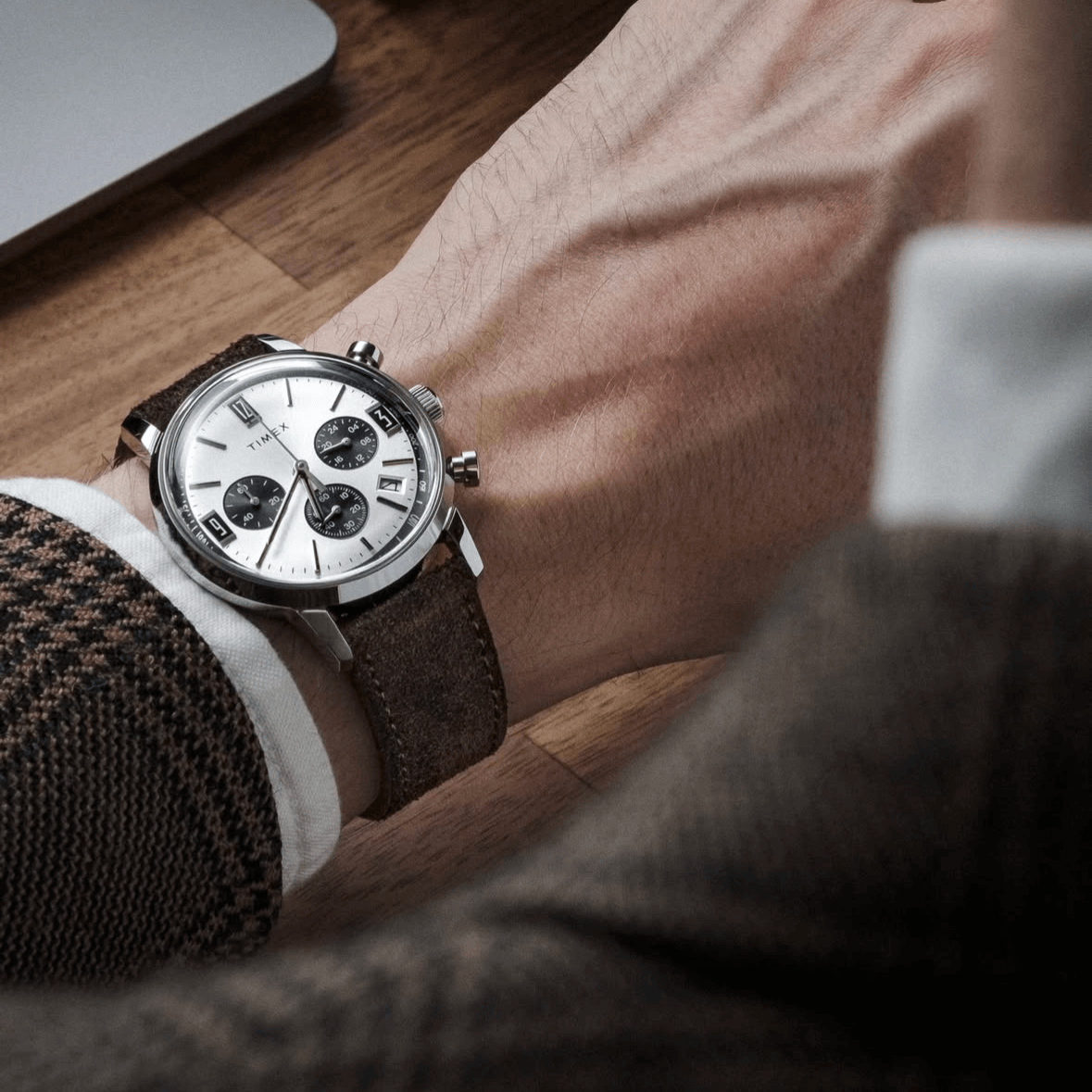 Nizza – Uhrenarmband aus feinem Wildleder an einem Handgelenk mit Uhr auf Holzuntergrund