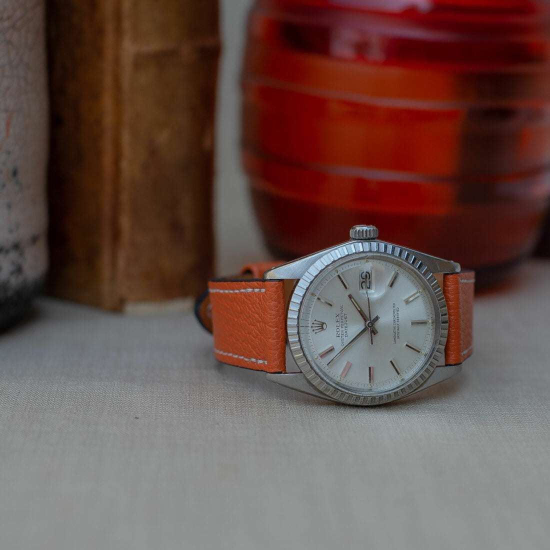 Seitlich fotografiertes oranges Ziegenlederarmband an einer Rolex Datejust, das einen lebendigen Akzent und hervorragenden Komfort bietet.