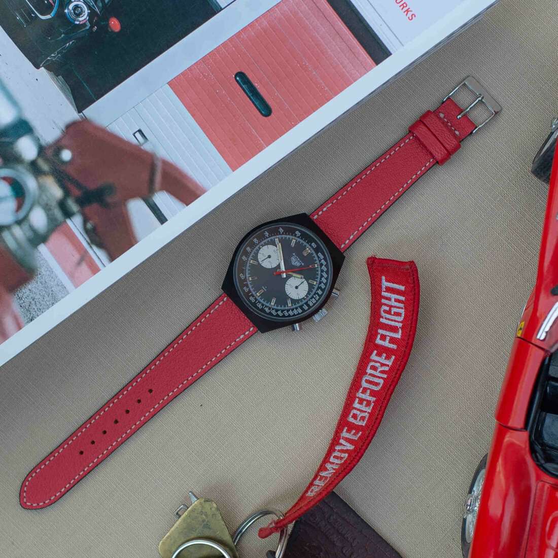 Rotes Ziegenlederarmband an einer Heuer Autavia, das sportlichen Stil und hochwertigen Komfort vereint.