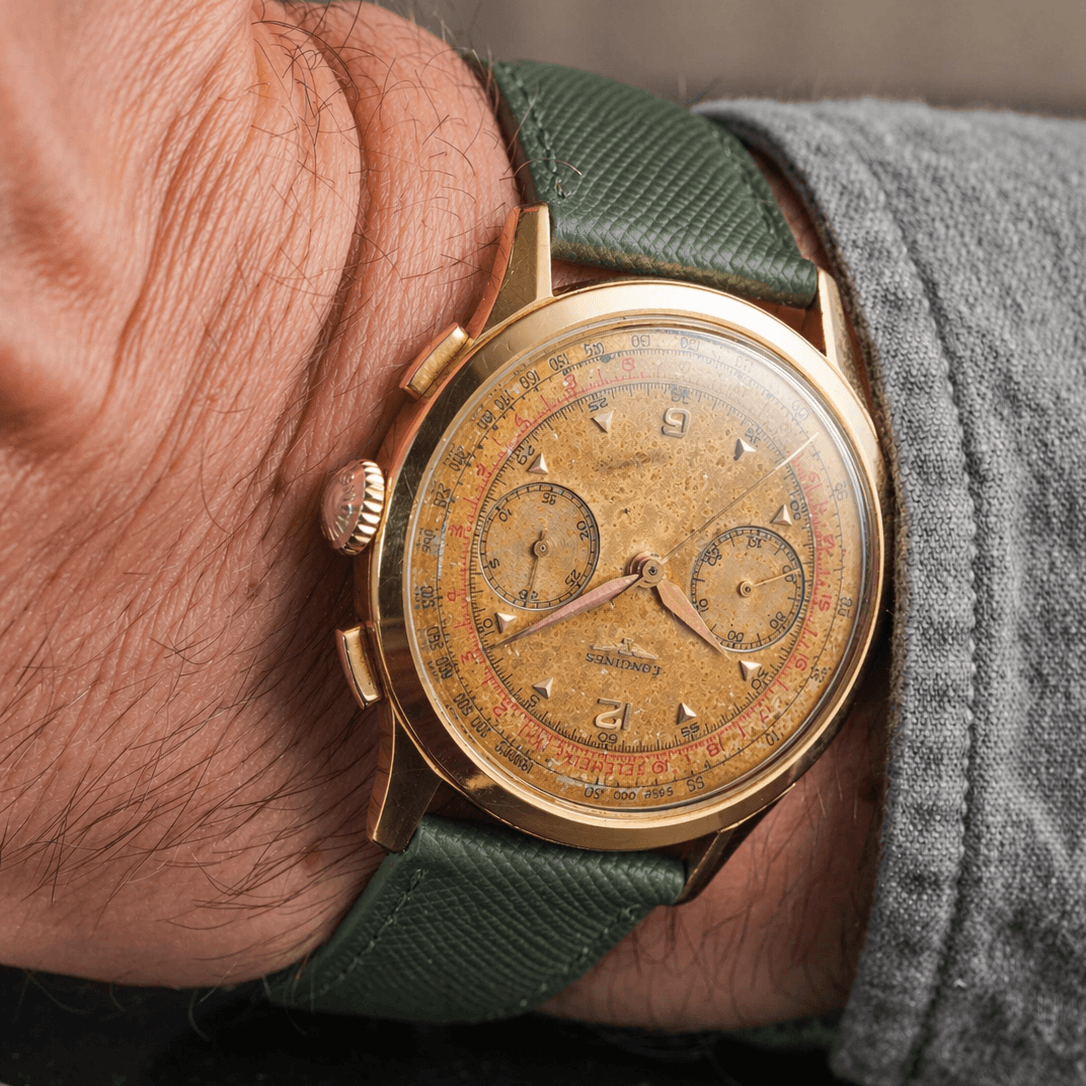 Saffiano – Uhrenarmband mit charakteristischer Saffiano Kreuzprägung an einer Vintage-Gold-Chronograph-Uhr.