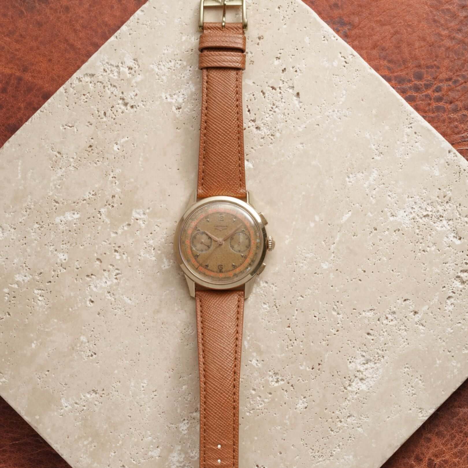 Saffiano – Uhrenarmband mit charakteristischer Saffiano Kreuzprägung an einer Longines-Vintage-Gold-Chronograph-Uhr.