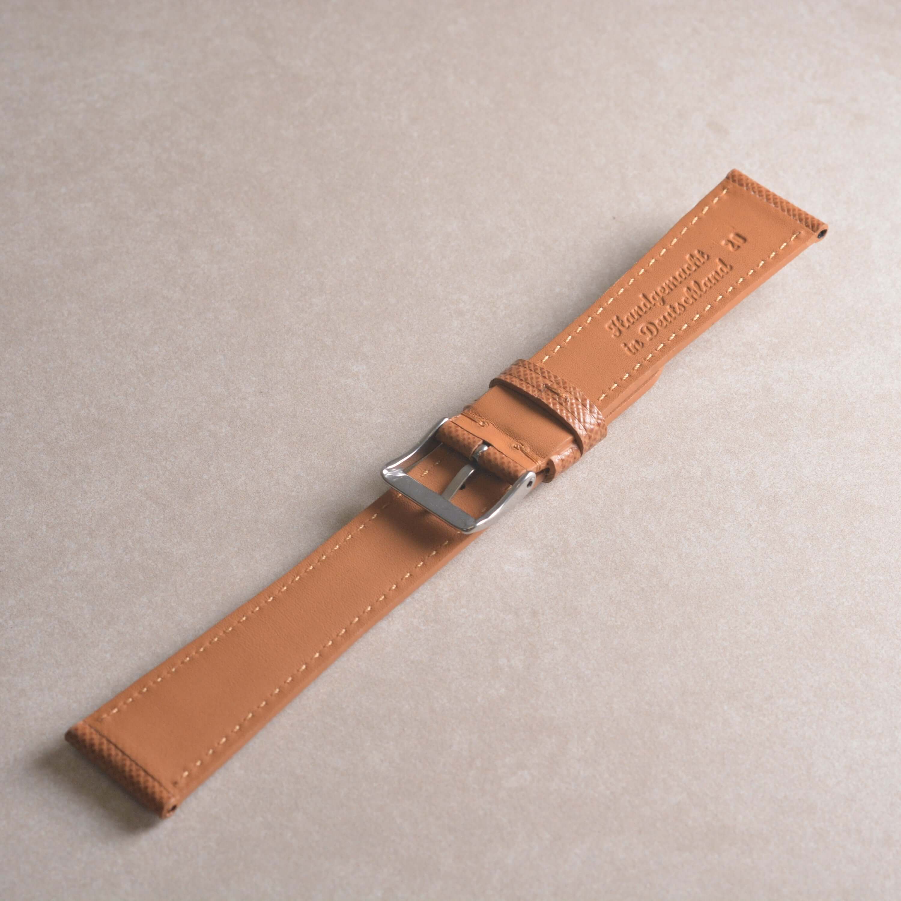 Saffiano – Uhrenarmband mit charakteristischer Saffiano Kreuzprägung auf einem neutralen Hintergrund.