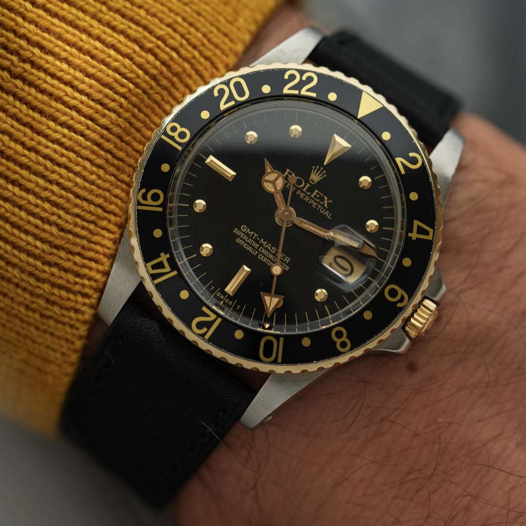 Schwarzes Barenia Glattleder 20mm Uhrenarmband an Rolex GMT Master Schwarz/Gold – Detailaufnahme der Uhr mit hochwertigem, strapazierfähigem schwarzem Barenia Glattlederarmband, ideal für luxuriöse Zeitmesser wie die Rolex GMT Master