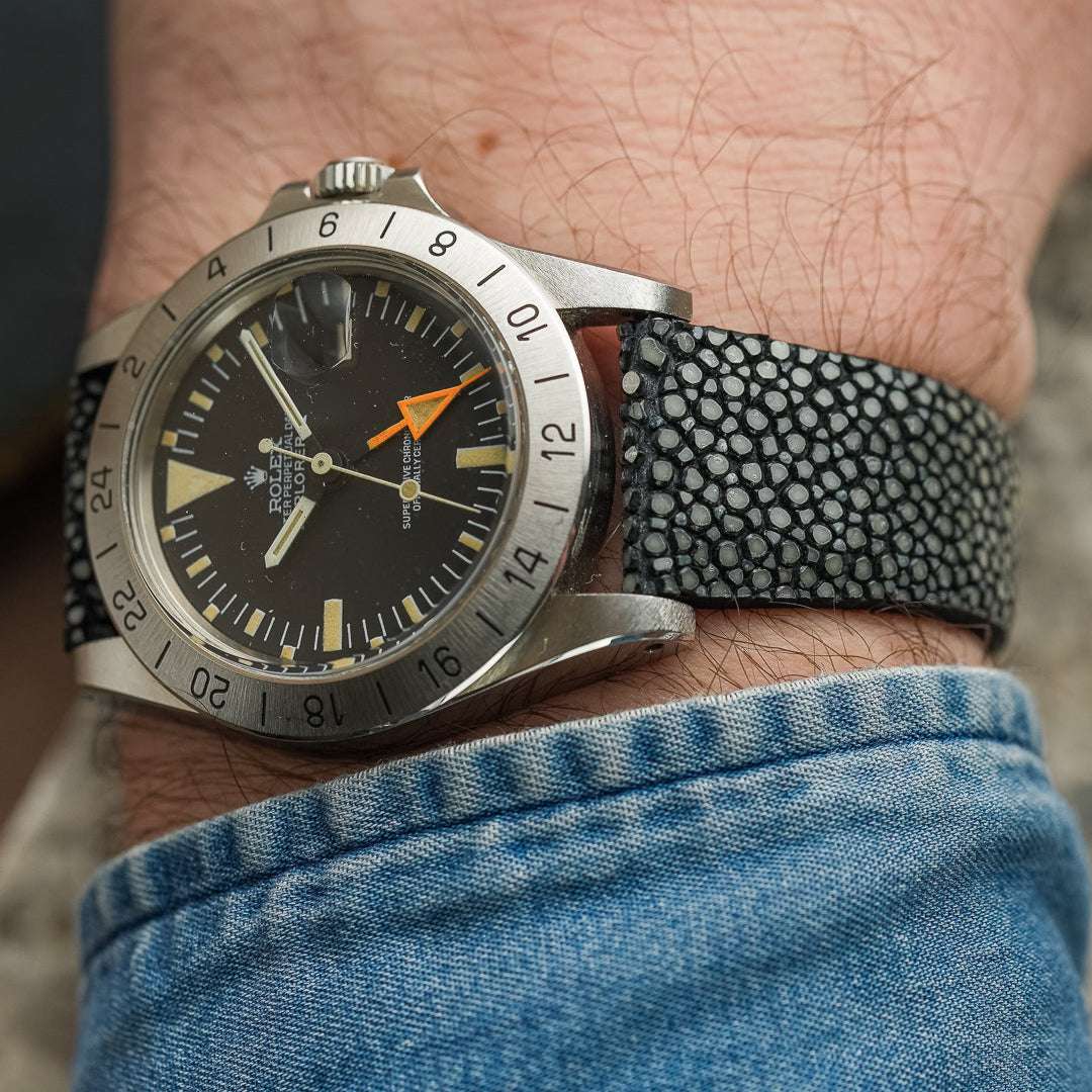 Rolex Explorer 2 aus dem Jahr 1974 mit oranger 24-Stunden-Hand, getragen mit einem schwarzen Perlrochen-Uhrenarmband am Handgelenk, sportlich-eleganter Vintage-Stil