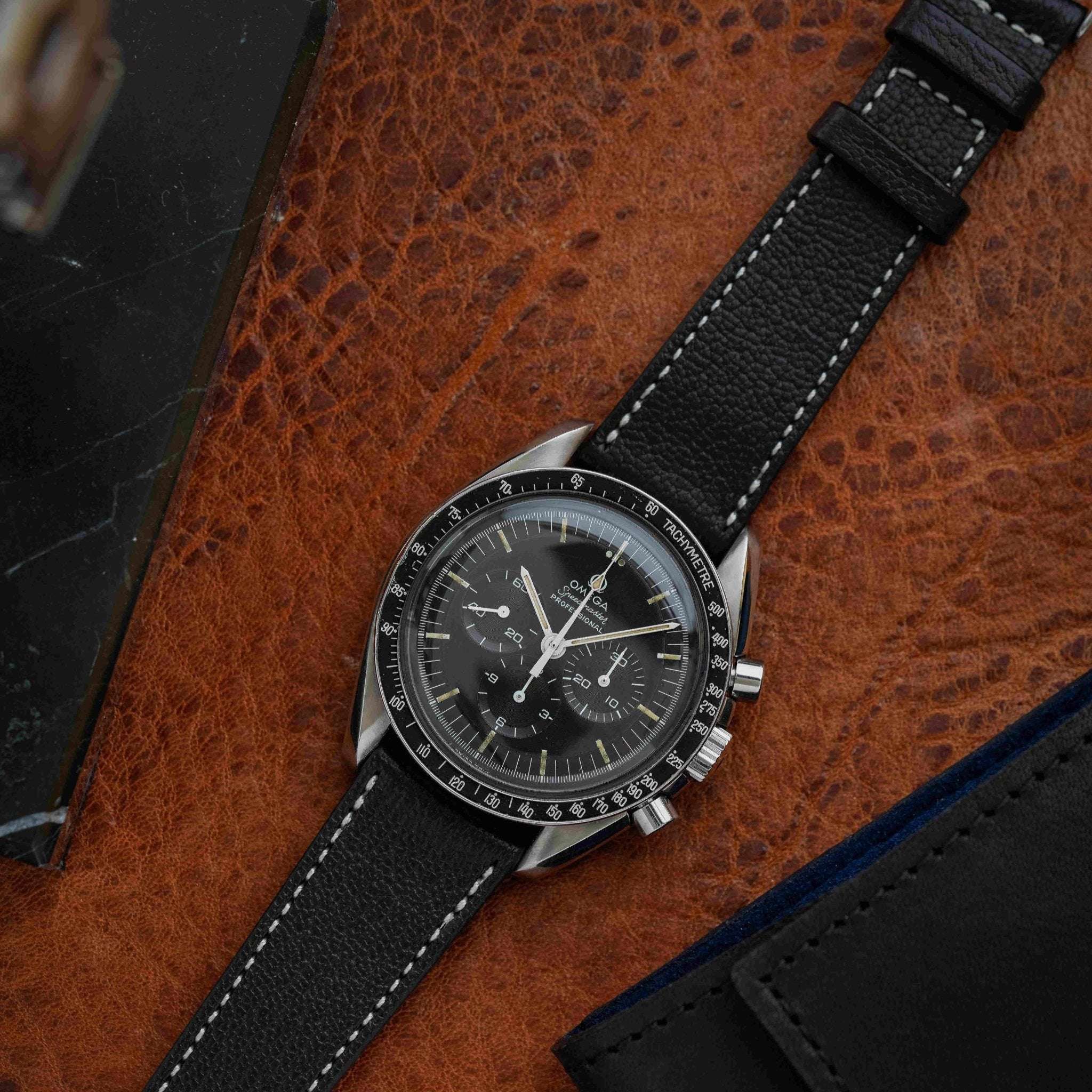 Schwarzes Ziegenleder-Uhrenarmband an einer Omega Speedmaster, das klassischen Stil mit hochwertigem Tragekomfort kombiniert.