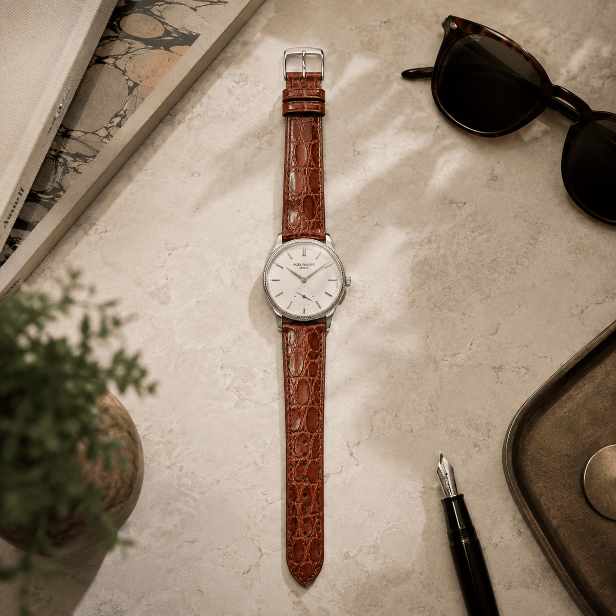 Shiny – Uhrenarmband aus glänzendem Kaimanleder an einer eleganten Uhr auf einem Tisch.