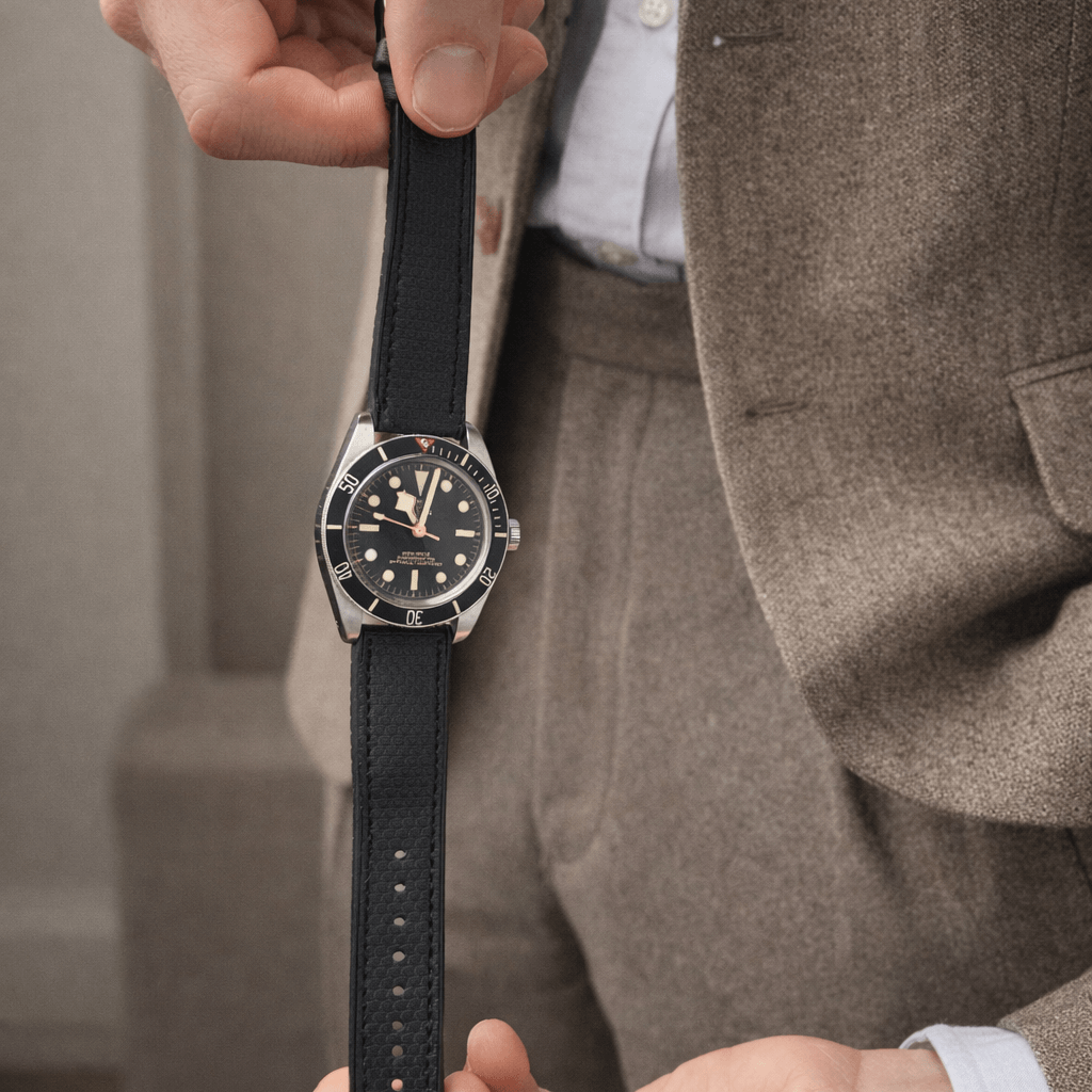Triton – wasserfestes Performance-Uhrenarmband an einer eleganten Uhr präsentiert von einer Person in Anzug, ideal für Alltag und Sport.