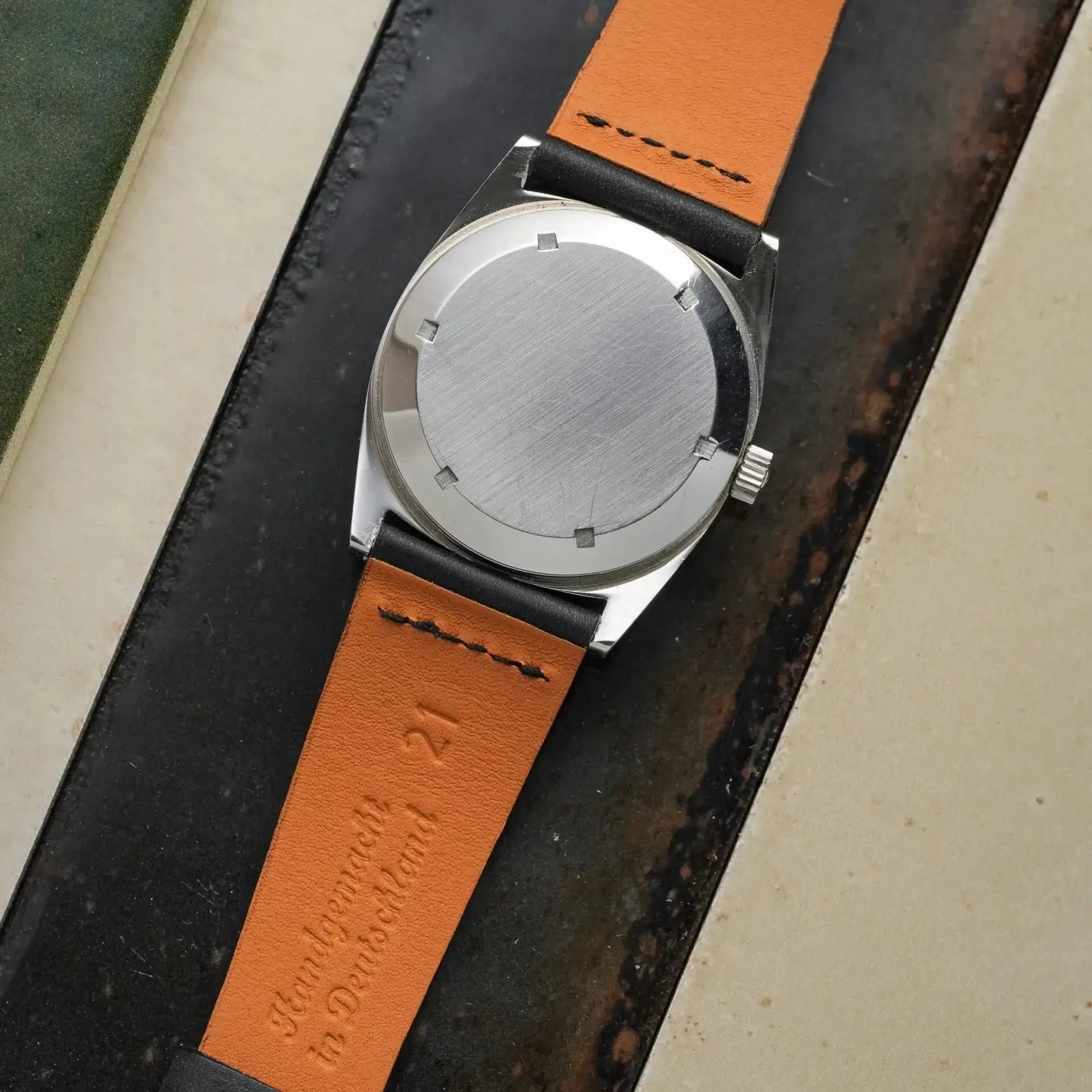 Paris – Uhrenarmband aus Barenia-Leder von Haas, Rückansicht einer Uhr mit orangefarbenem Lederarmband.