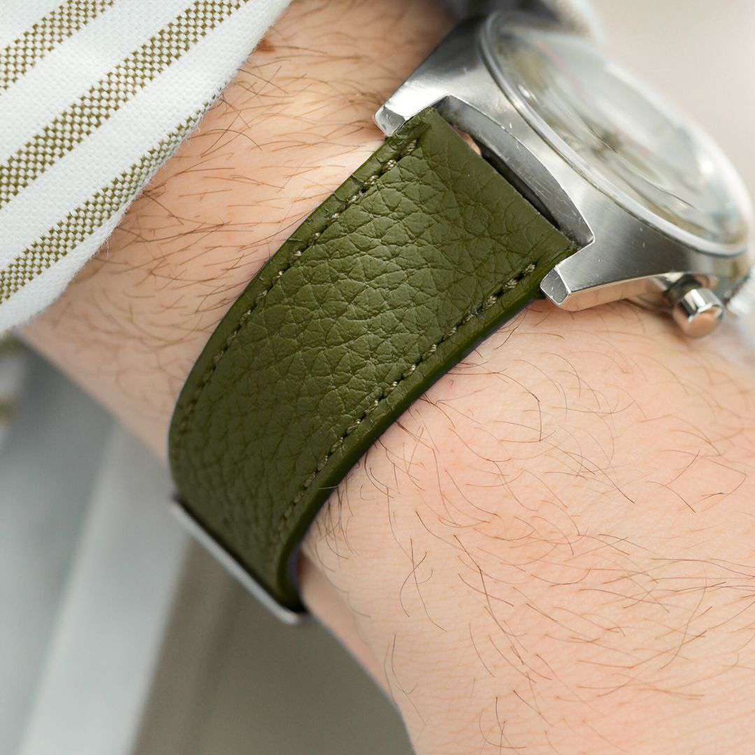 Detailaufnahme des Togo Uhrenarmbands 20mm in Olive am Handgelenk. Das weiche Kalbleder aus der Gerberei Perlinger bietet höchsten Tragekomfort, während die feine Narbung eine luxuriöse Optik verleiht.