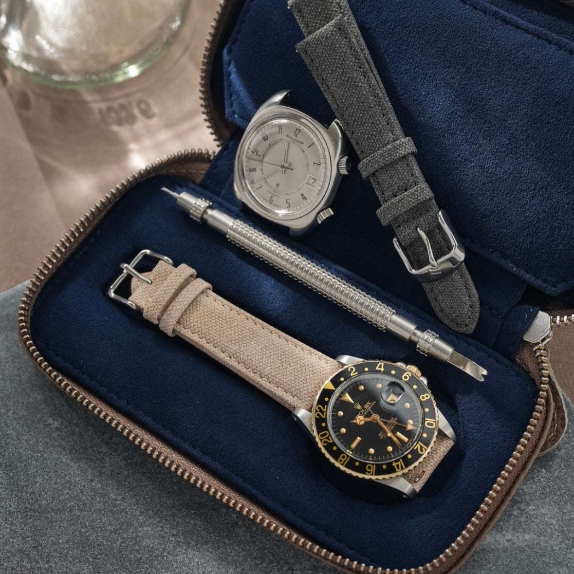 Innenansicht eines taupefarbenen Uhrenetuis für zwei Uhren mit Ton-in-Ton-Naht und blauem Alcantara-Innenfutter. Im Inneren befindet sich eine Rolex Explorer, die das elegante und hochwertige Design des Etuis ergänzt.