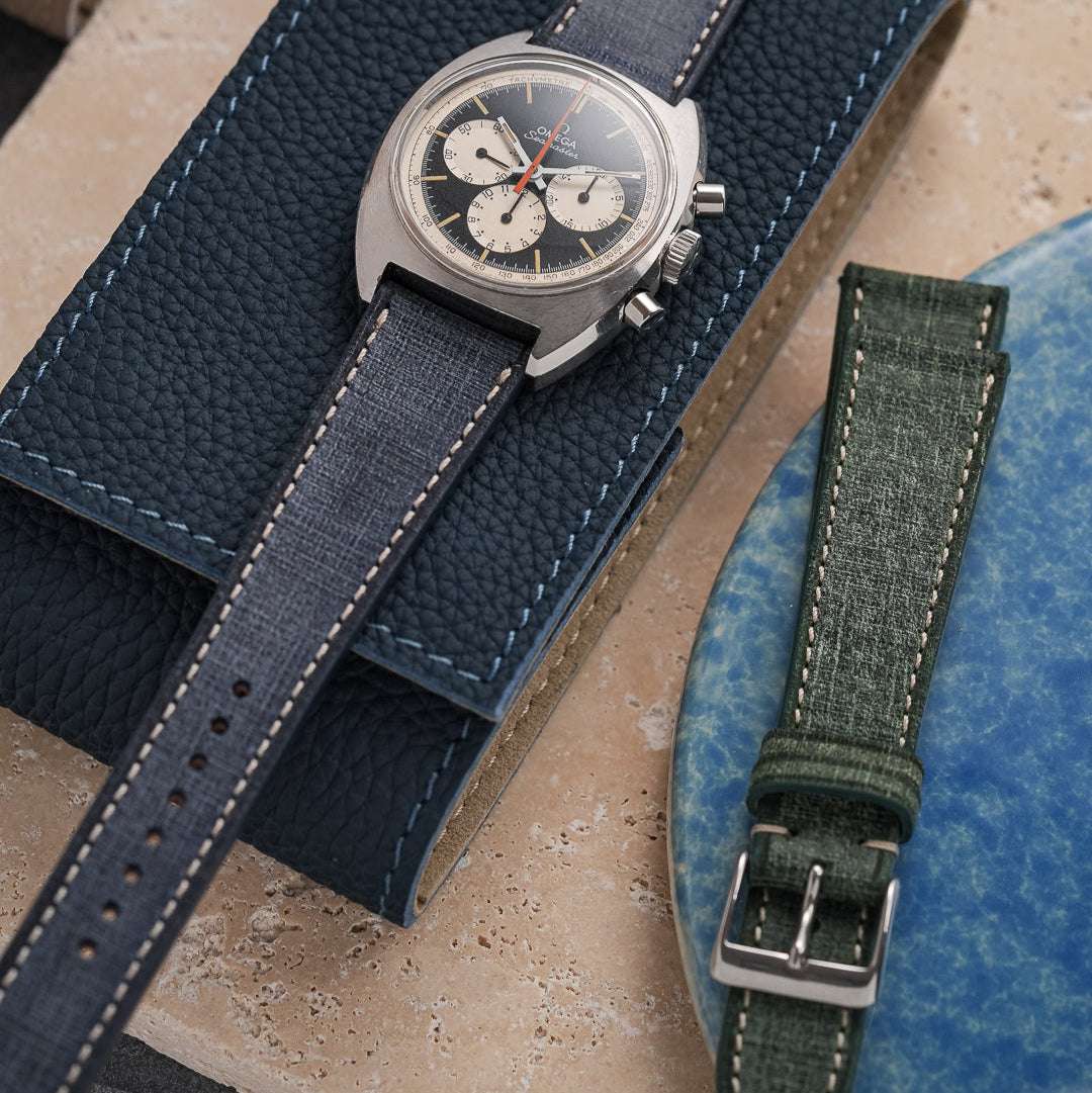 Uhrenetui aus royalblauem Togo-Leder mit einer Omega Seamaster auf einem blauen Lederband, präsentiert auf dem Etui, luxuriöse und elegante Aufbewahrung für hochwertige Uhren