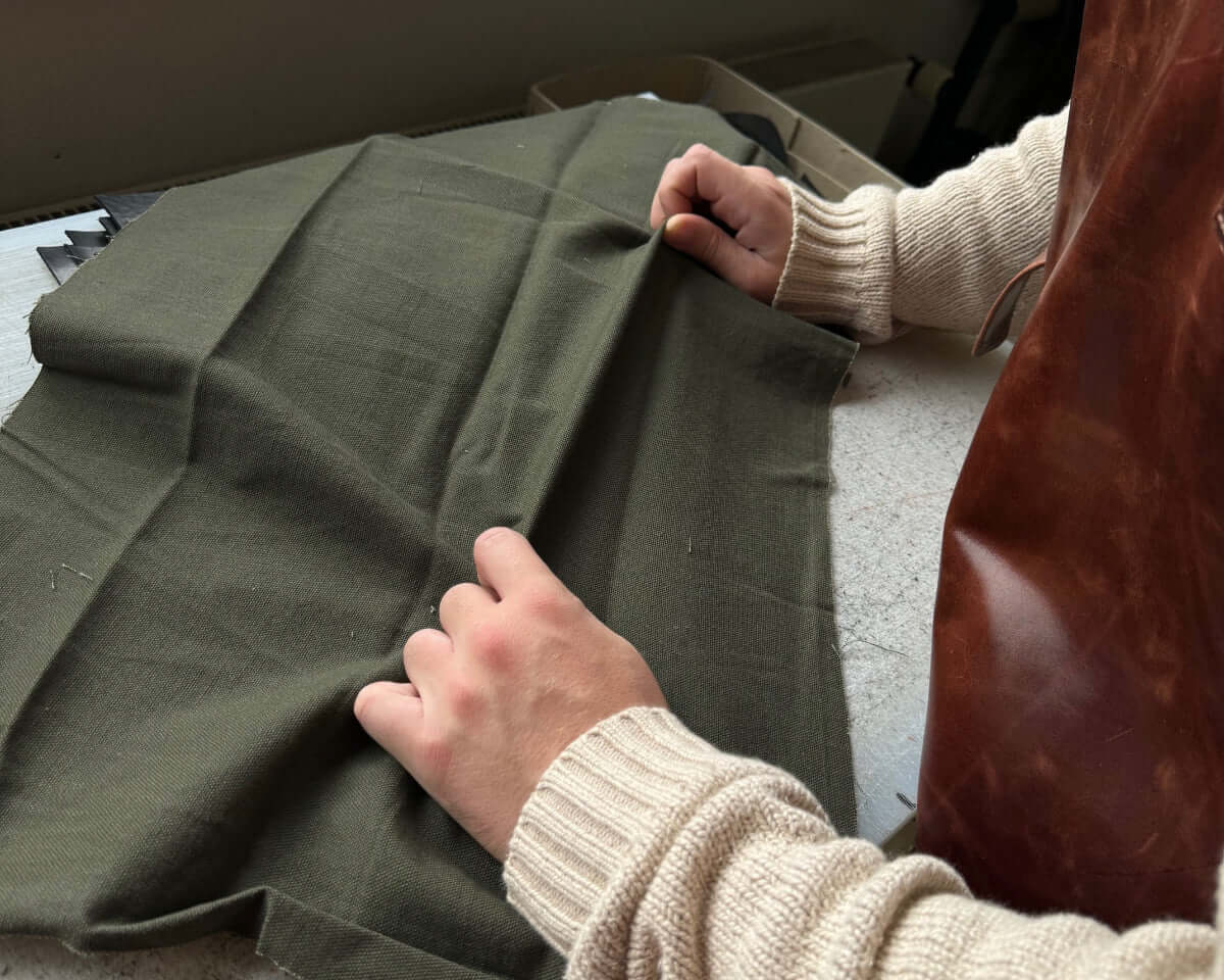 Verarbeitung eines Canvas Stoff Uhrenarmbands in der Fluco Manufaktur – Detailaufnahme der präzisen Bearbeitung eines Canvas Stoff Uhrenarmbands in der Fluco Manufaktur. Das Bild zeigt die Handwerkskunst und Sorgfalt, mit der der strapazierfähige Canvas-Stoff verarbeitet wird, um ein langlebiges und komfortables Uhrenarmband zu schaffen.