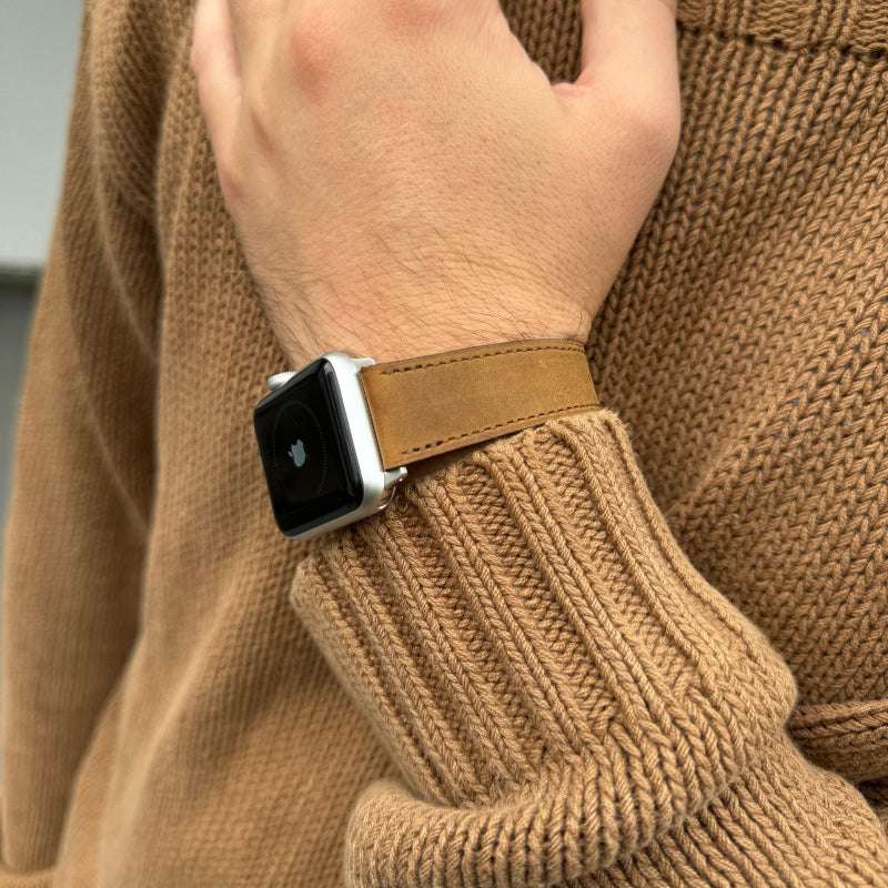 Whiskyfarbenes Nubukleder-Armband für Apple Watch am Handgelenk – Frontansicht mit braunem Pullover